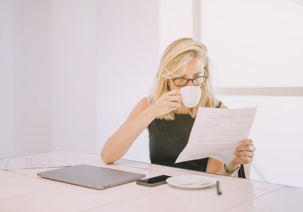 young-businesswoman-drinking-coffee-while-reading-document-office.jpg сотрудница